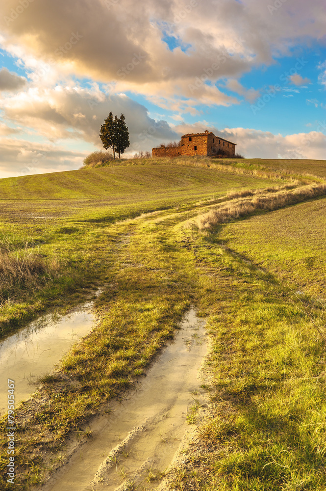 Abandoned buildings between the Tuscan fields with blue cloudy s