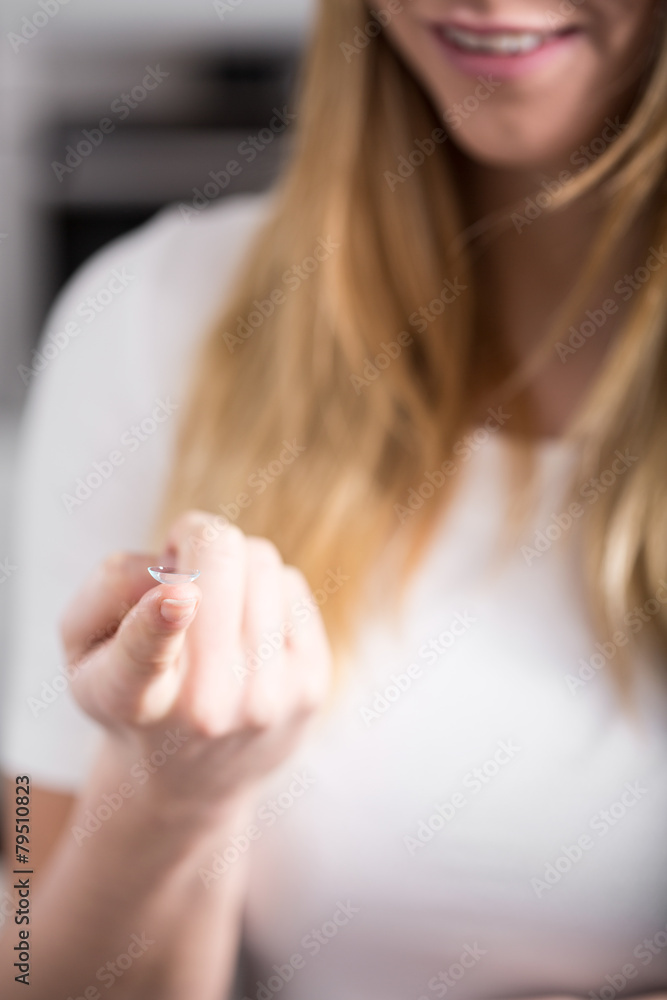 Naklejka premium Woman holding contact lens