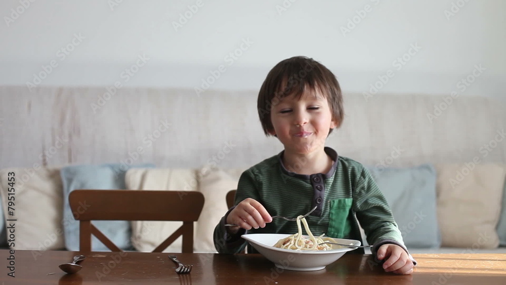 Adorable little boy, eating spaghetti at home, homemade pasta Adorable little boy, eating spaghetti at home, homemade pasta