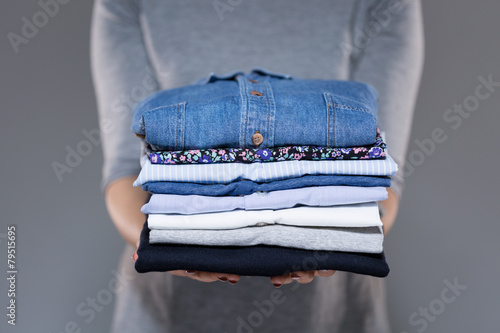 Woman holding clothes in hands photo