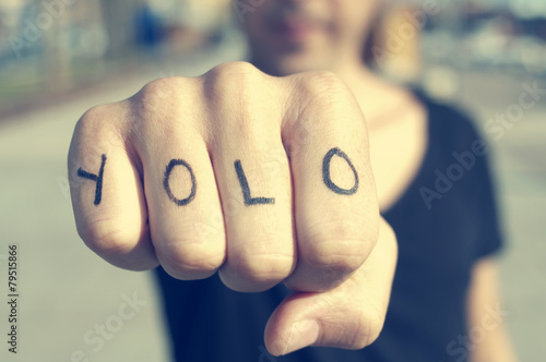 young man with the word yolo, for you only live once, tattooed i photo
