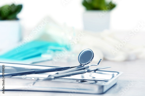 Dentist tools in metal tray on table close up photo