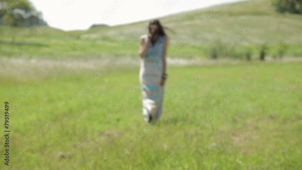 Young woman walking in nature with wind blowing her hair Young woman walking in nature with wind blowing her hair