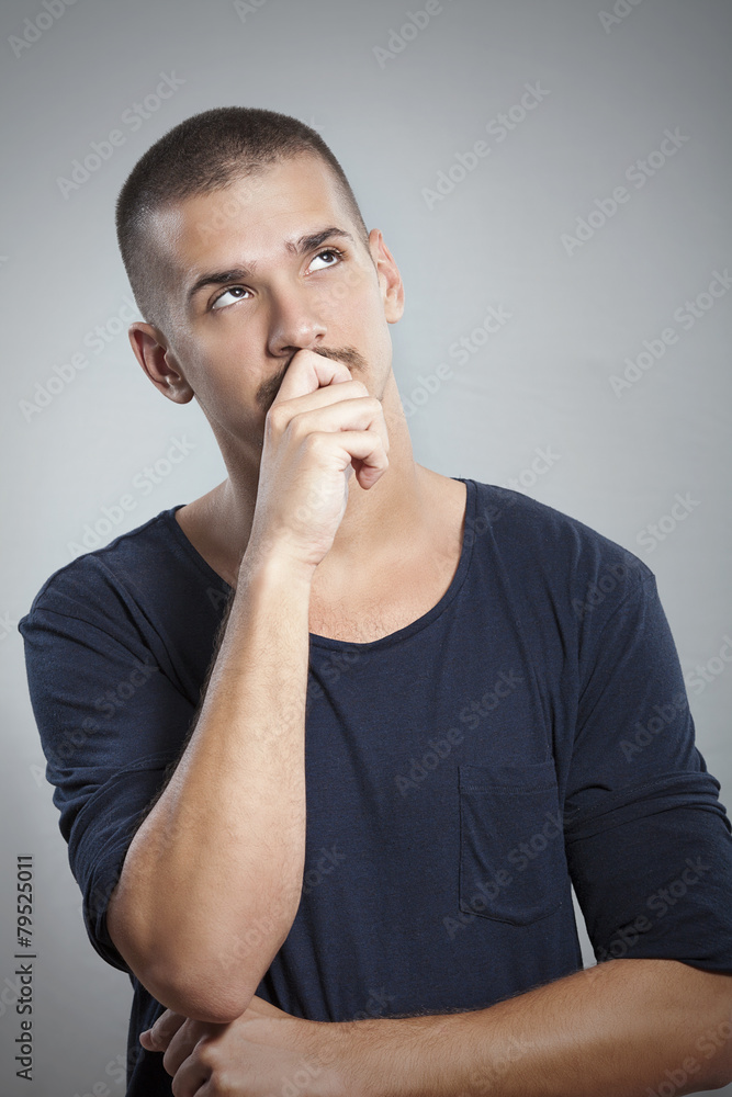 Studio shot of young man thinking Studio shot of young man thinking