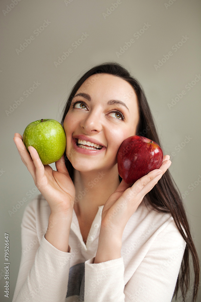 Young woman holds two apples and smiling Young woman holds two apples and smiling