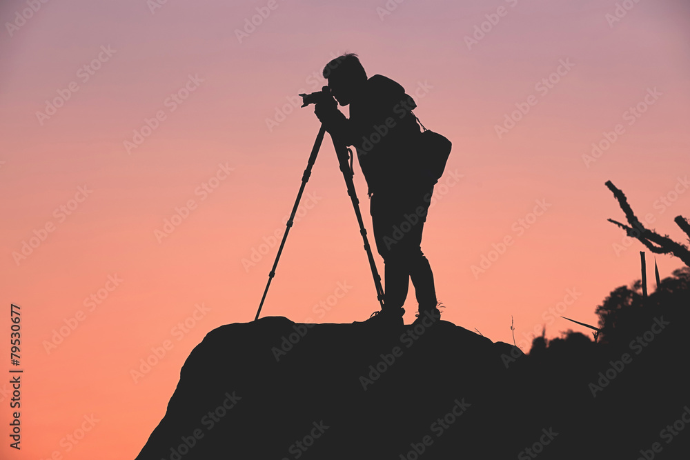 Silhouette of a photographer who shooting a sunset in the mounta