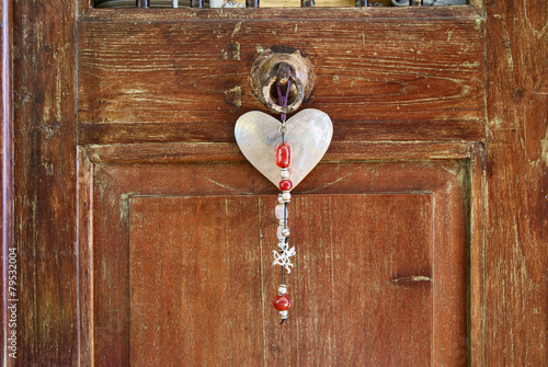 Love talisman hanging from hardwood cupboard photo