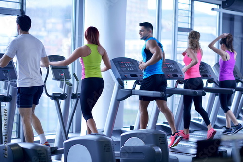 Group of people running on treadmills #79532649