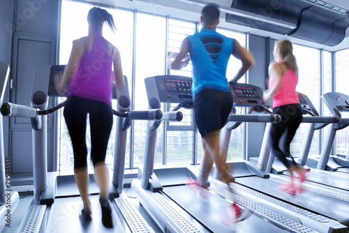 Group of people running on treadmills