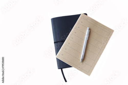 Brown and black notebook and pen