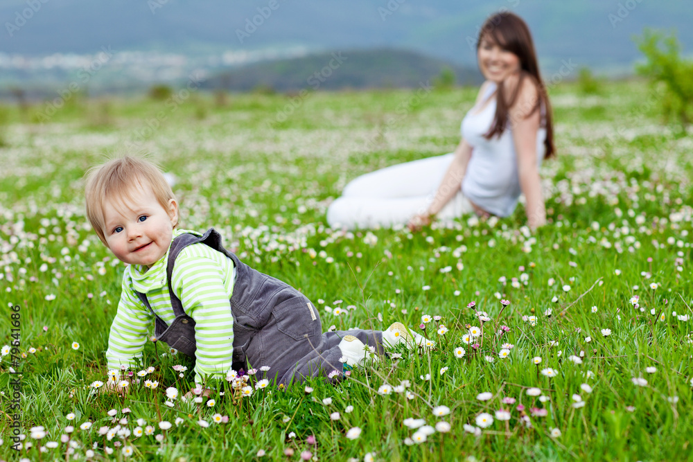 Happy mother are playing with baby in flowers field Happy mother are playing with baby in flowers field