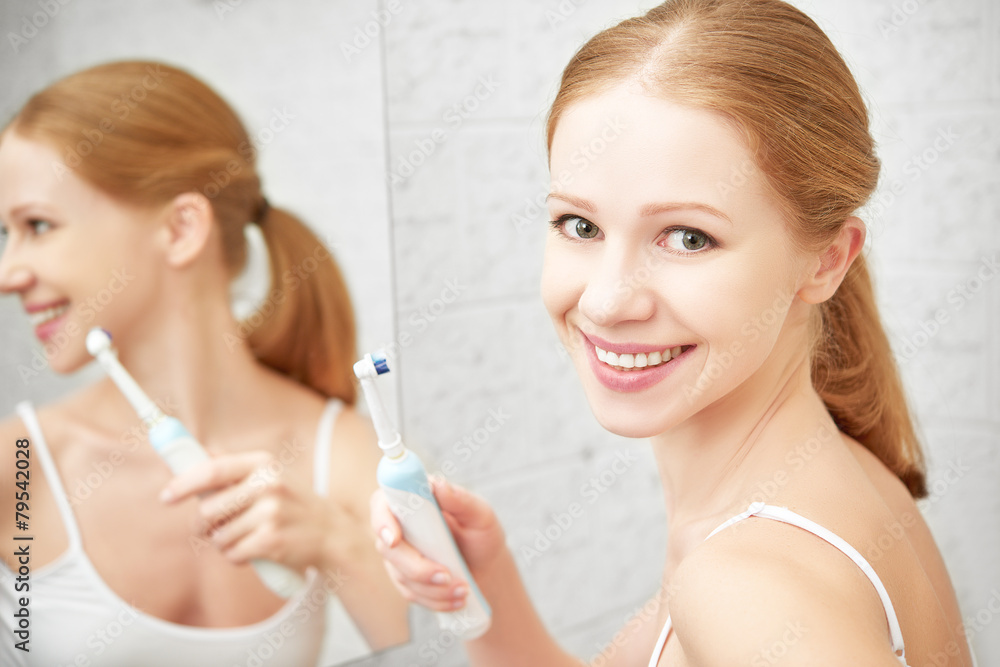 young healthy woman brushing her teeth with a toothbrush in bat young healthy woman brushing her teeth with a toothbrush in bat