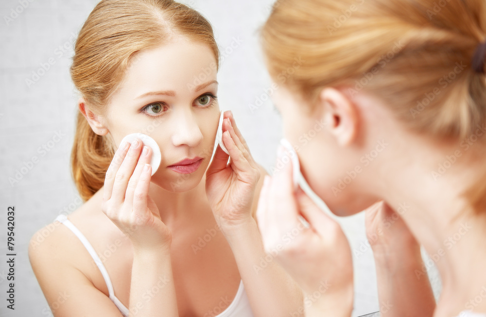 beautiful young woman removes makeup with face skin in the mirro beautiful young woman removes makeup with face skin in the mirro