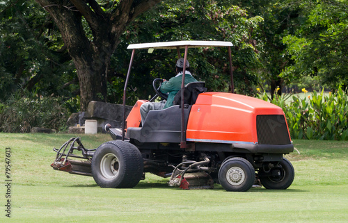 Man work gardener riding mower machine in golf course.