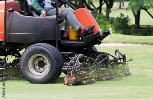 Man Worker riding mower machine cutting fairway.
