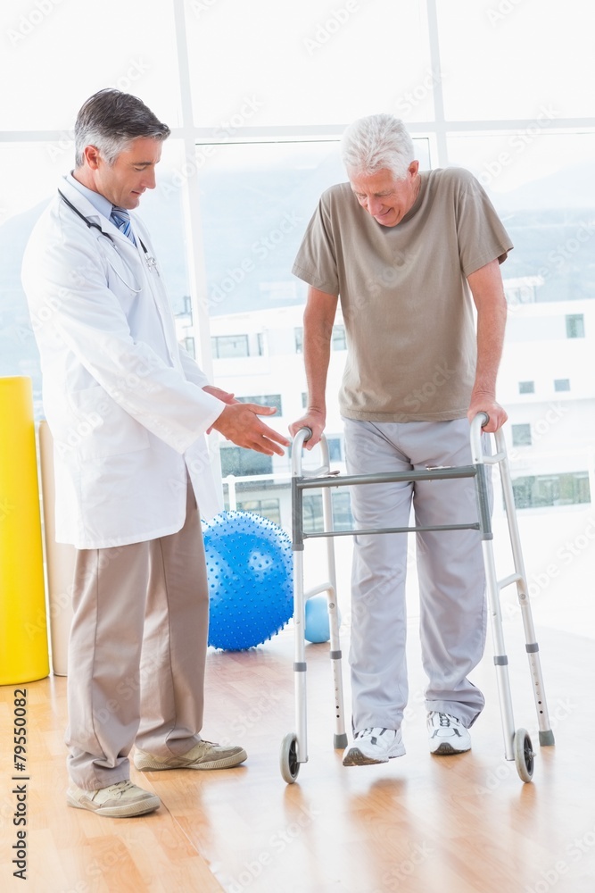 Senior man on zimmer frame with therapist Senior man on zimmer frame with therapist