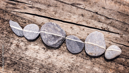 Lign of stones on a wooden background
