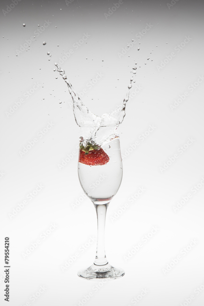 fresh strawberry dropped into water with splash on white backgro fresh strawberry dropped into water with splash on white backgro