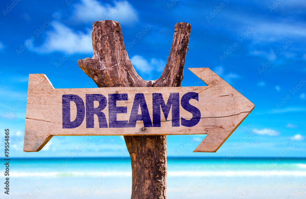 Dreams wooden sign with beach background