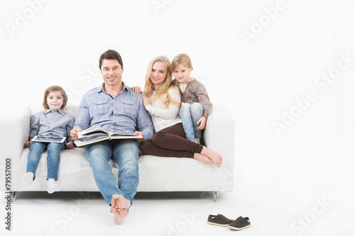 Happy family on the couch reading a book