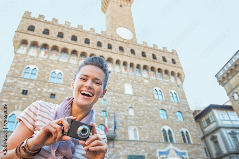 Portrait of happy young woman with photo camera in firenze