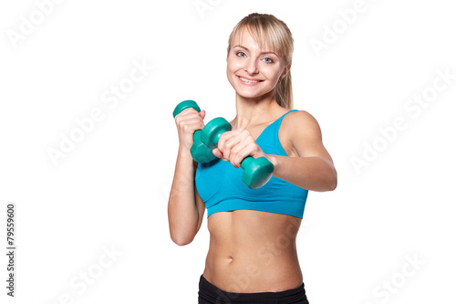 Young woman smiling while using dumbbells against a white backgr