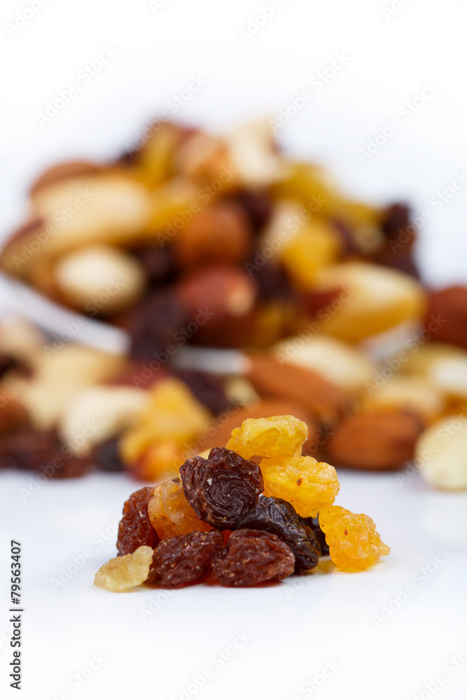 Mixed nuts and sultanas on a plate on a white background