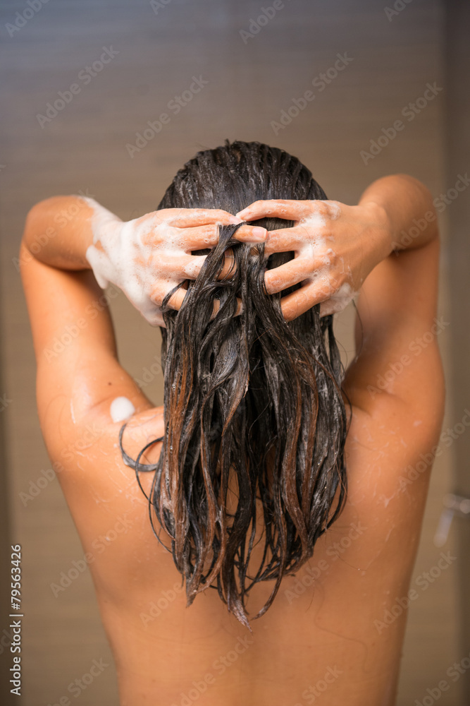 Naklejka premium Woman taking a shampoo