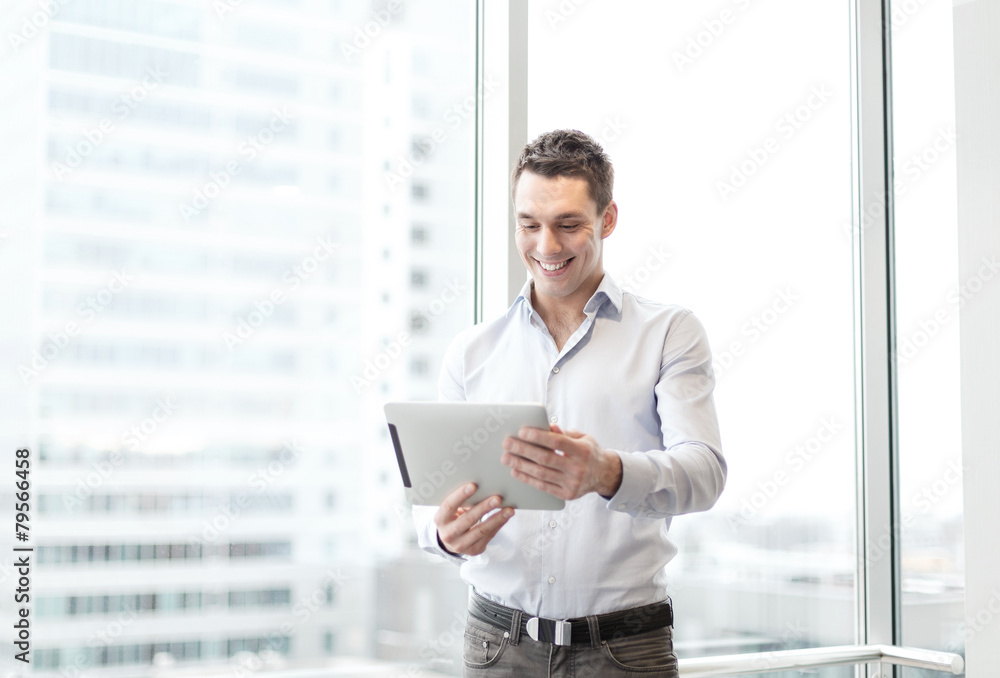 smiling businessman with tablet pc in office