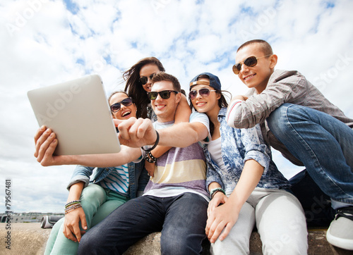 group of teenagers looking at tablet pc © Syda Productions