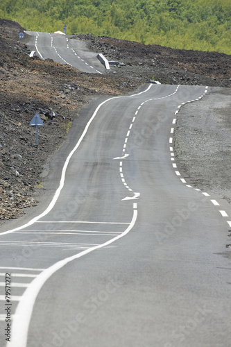 Curved asphalt road over volcanic lava, Reunion island, France.