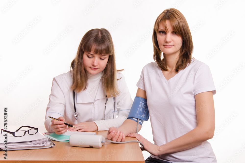 Physician writes tonometer readings in the patient card Physician writes tonometer readings in the patient card