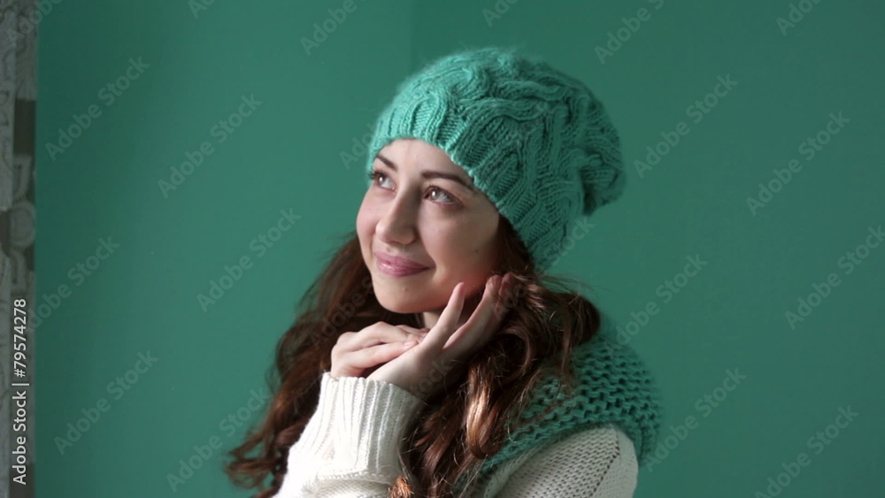 smiling girl in a turquoise knitted hat posing on camera smiling girl in a turquoise knitted hat posing on camera