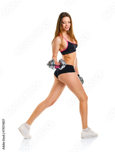 Beautiful athletic woman with dumbbells doing sport exercise, is