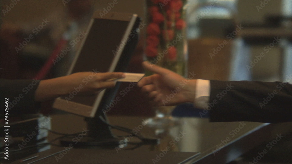 CU OF A BUSINESSMAN CHECKING IN AT A RECEPTION DESK CU OF A BUSINESSMAN CHECKING IN AT A RECEPTION DESK