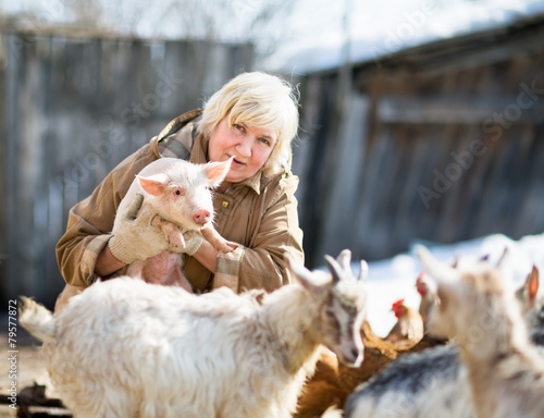 Schilderij op canvas female farmer holding a small pig
