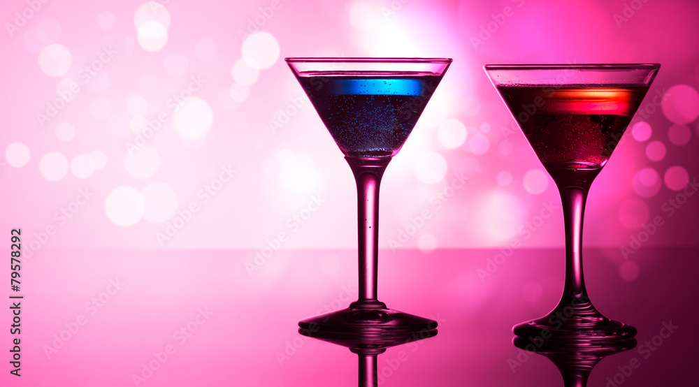 Colorful cocktails on reflective top, with bokeh background Colorful cocktails on reflective top, with bokeh background