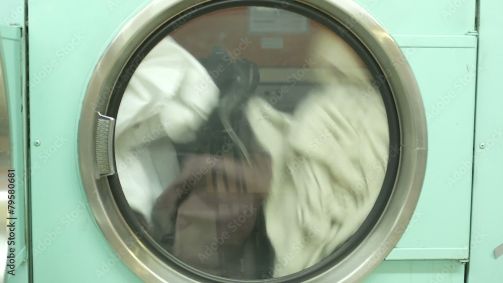 A Washing Machine spins rapdly, cleaning clothes A Washing Machine spins rapdly, cleaning clothes