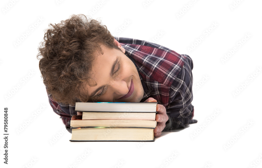 Happy man sleeping on the table with books Happy man sleeping on the table with books