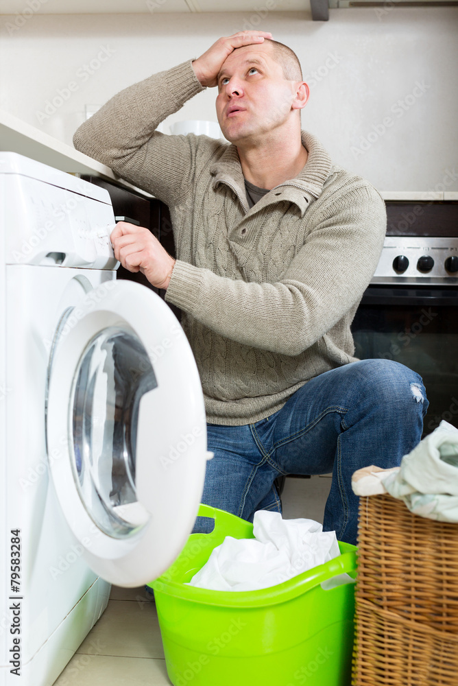 Sad guy using washing machine