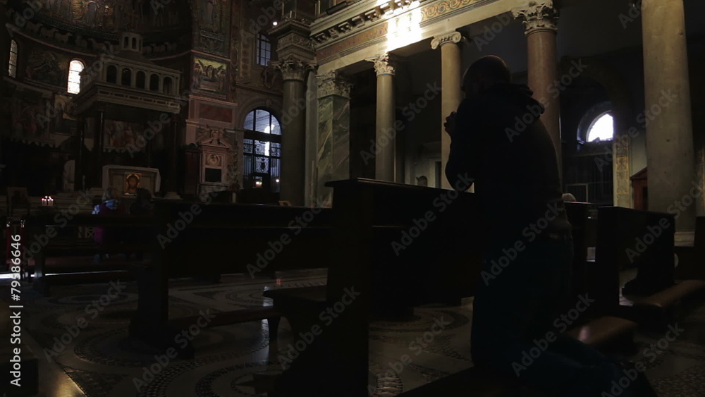 A man prays in historical cathedral in Rome A man prays in historical cathedral in Rome