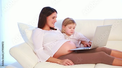 pregnant mother watching a video with her daughter