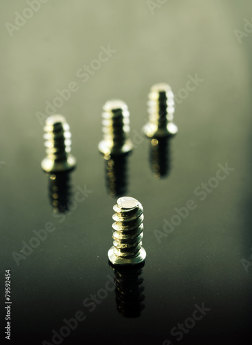 Focus on one screw from a group of four on a vintage background