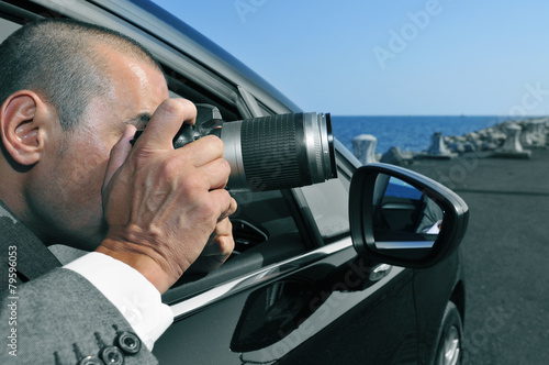 Fotografie detective or paparazzi taking photos from inside a car
