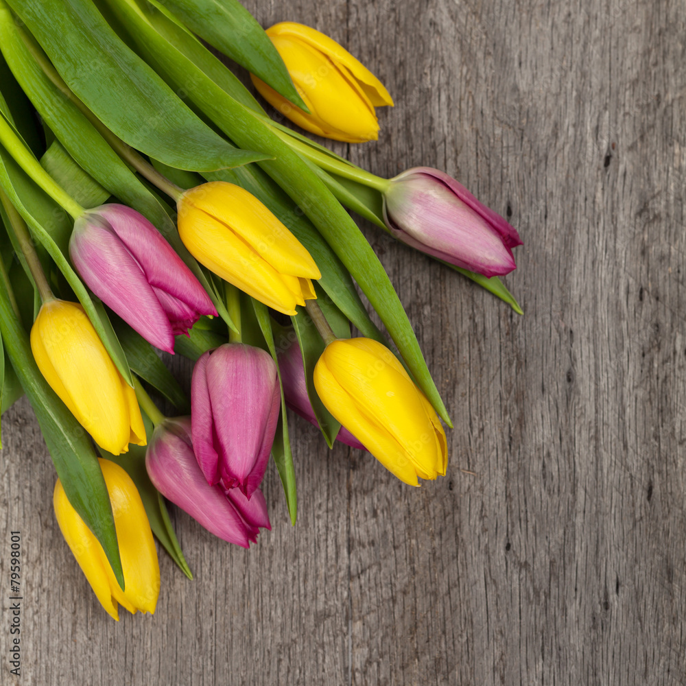 Tulips on wood table with space for text. Selective focus. Tulips on wood table with space for text. Selective focus.