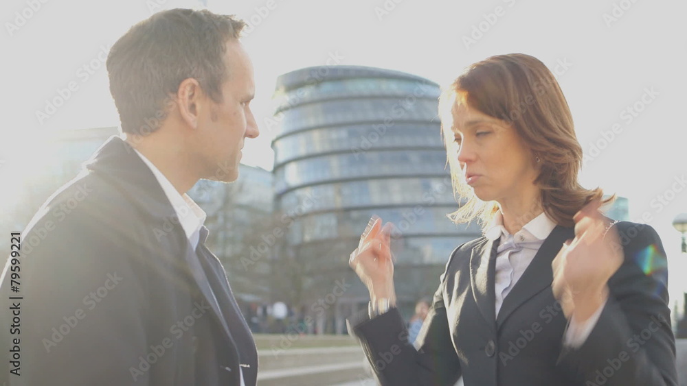 Business and man and woman stand outside office discussing plans Business and man and woman stand outside office discussing plans