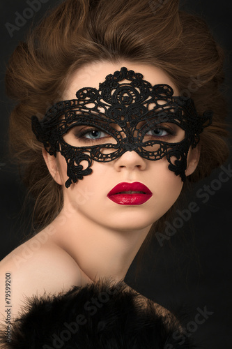Portrait of young adorable woman in black party mask