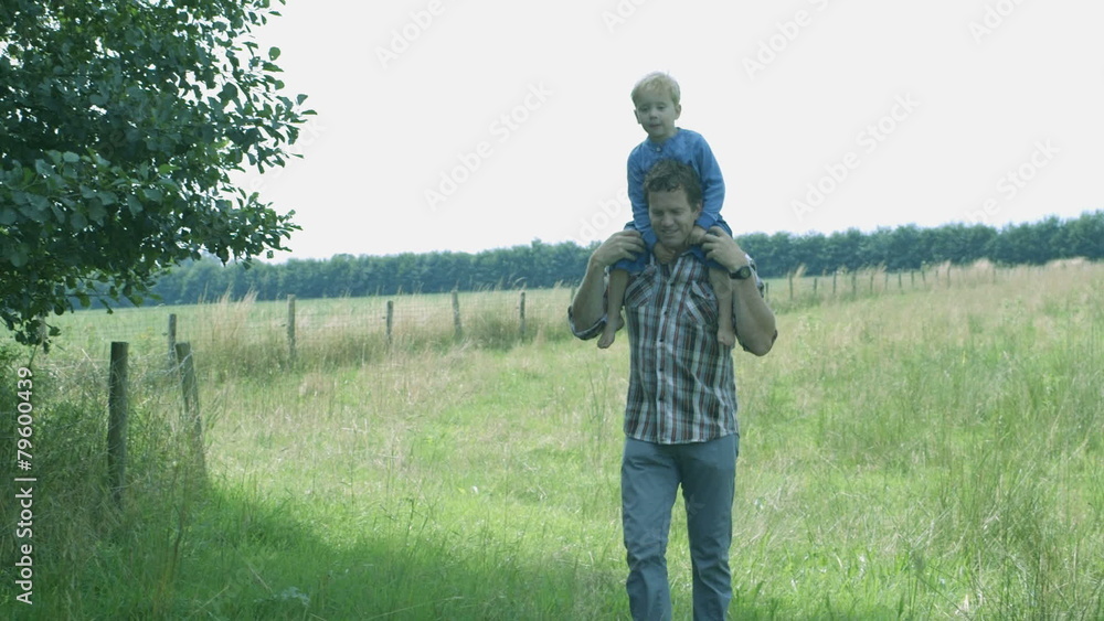 WS PAN Father carrying son on his shoulder WS PAN Father carrying son on his shoulder