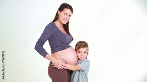 little boy kisses her mother paunch