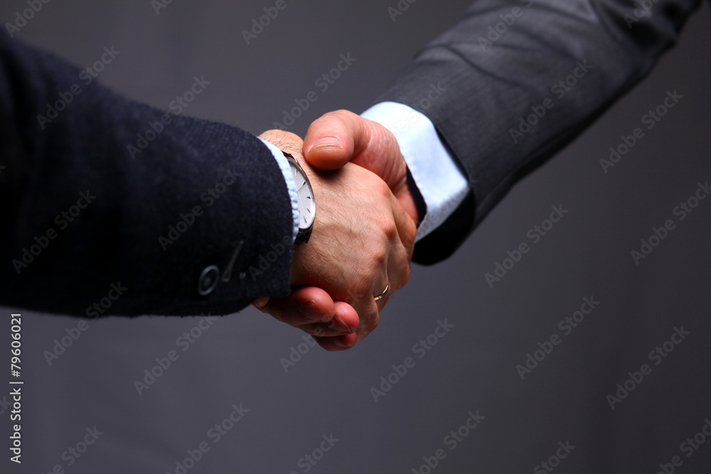 Closeup of a business handshake, on gray background